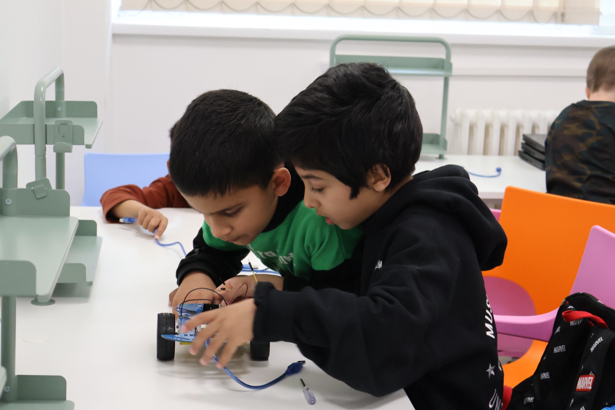 Two Robocoders working together on an Arduino robot build.